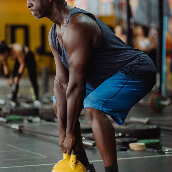 Focused man holding a kettlebell, showing concentration and body control.